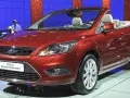 Roter Ford Focus Coupé-Cabriolet auf einer Messe. Ein Blick auf den **Ford Focus Wartungsplan** hilft, diesen Wagen in Topform zu halten.