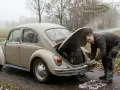 Mann repariert seinen Käfer, der beim Gas geben ruckelt. Werkzeug liegt bereit.