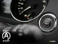 Startknopf im Auto mit Kreis und Pfeilen, bereit für die Fahrt.