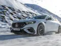 Weißer Mercedes-AMG mit 4MATIC fährt durch verschneite Berglandschaft.
