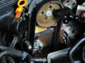 Ein Mechaniker arbeitet am Zahnriemenwechsel. Wann ist der richtige Zeitpunkt dafür?