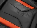Detailaufnahme eines schwarzen Ledersitzes mit orangefarbenen Akzenten. Perfekt für die Leder reinigen Pflege.