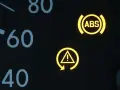 Gelbe Kontrollleuchten im Auto: ABS-Symbol und allgemeines Warnsymbol. Vorsicht ist geboten.