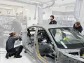 Mitarbeiter arbeiten an einem Auto-Chassis. Sie sind Teil eines Teams, das sich mit der Frage beschäftigt, was OEMs sind und wie sie in der Automobilproduktion eingesetzt werden.