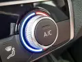Detailaufnahme des Cockpits eines Autos. Ein Drehregler mit blauer und roter Beleuchtung steuert die Klimaanlage.