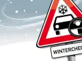 Warnschild mit Schneeflocke und Auto, Lupe zeigt auf Reifen. Darunter steht "WINTERCHECK". Bereiten Sie Ihr Fahrzeug auf den Winter vor!