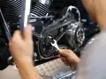 Mechaniker repariert Motorrad-Steuerkette. Die Kosten für den Wechsel der Steuerkette sind hier ein wichtiger Faktor.