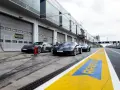 Porsche-Rennwagen in Boxengasse. Hier kann man pitstop teile selber mitbringen. Gelbe Markierungen auf dem Asphalt.