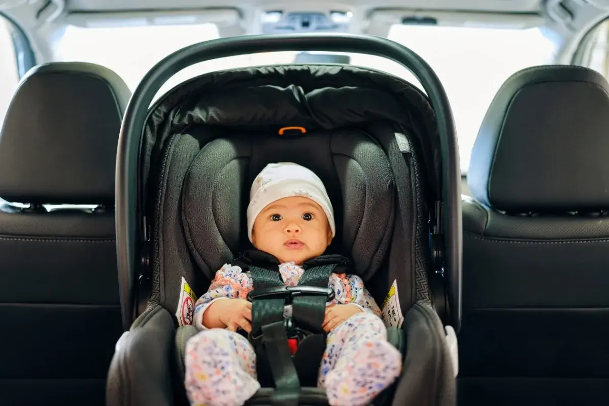 Kleines Baby im Kindersitz, bereit für die Fahrt. Die Frage "Kindersitz bis wann" beschäftigt viele Eltern.