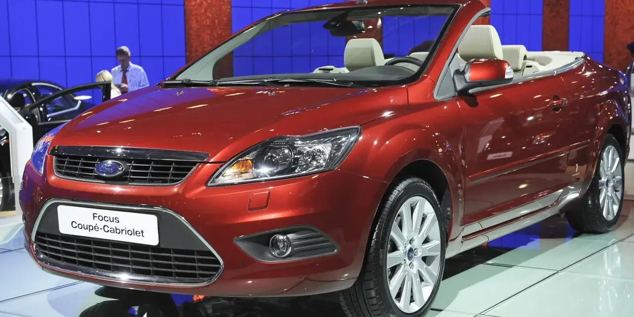 Roter Ford Focus Coupé-Cabriolet auf einer Messe. Ein Blick auf den **Ford Focus Wartungsplan** hilft, diesen Wagen in Topform zu halten.