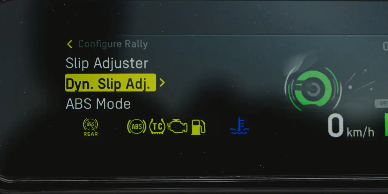 Fahrzeugdisplay zeigt Einstellungen für Traktionskontrolle (TC) und ABS. "Dyn. Slip Adj." ist hervorgehoben.