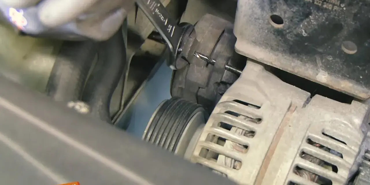 Werkzeug wird benutzt, um den Keilriemen zu spannen. Ein Keilriemen ist ein wichtiger Bestandteil des Motors.