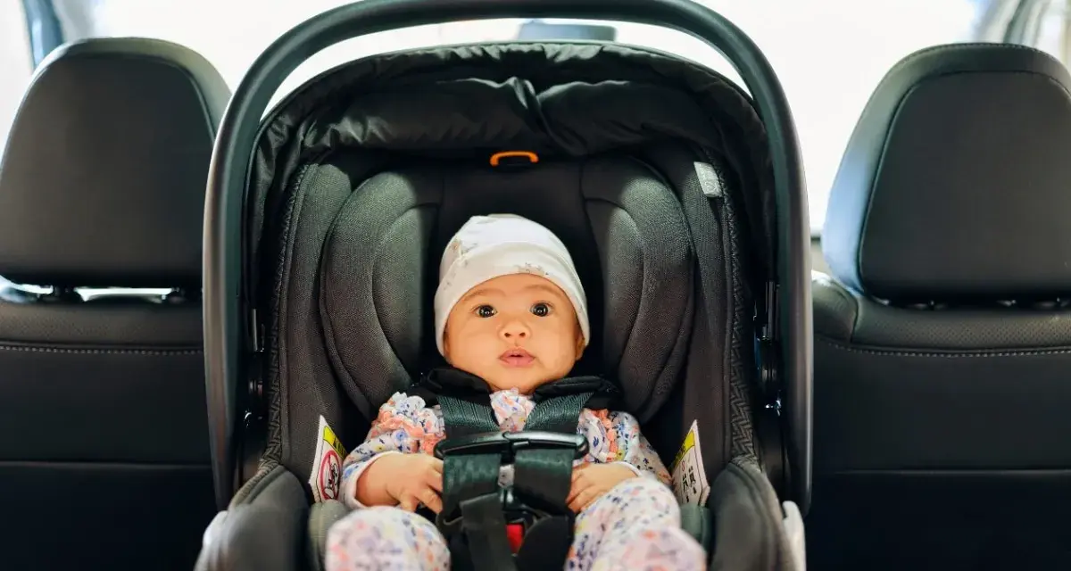 Kleines Baby im Kindersitz, bereit für die Fahrt. Die Frage "Kindersitz bis wann" beschäftigt viele Eltern.