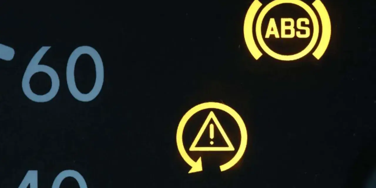 Gelbe Kontrollleuchten im Auto: ABS-Symbol und allgemeines Warnsymbol. Vorsicht ist geboten.