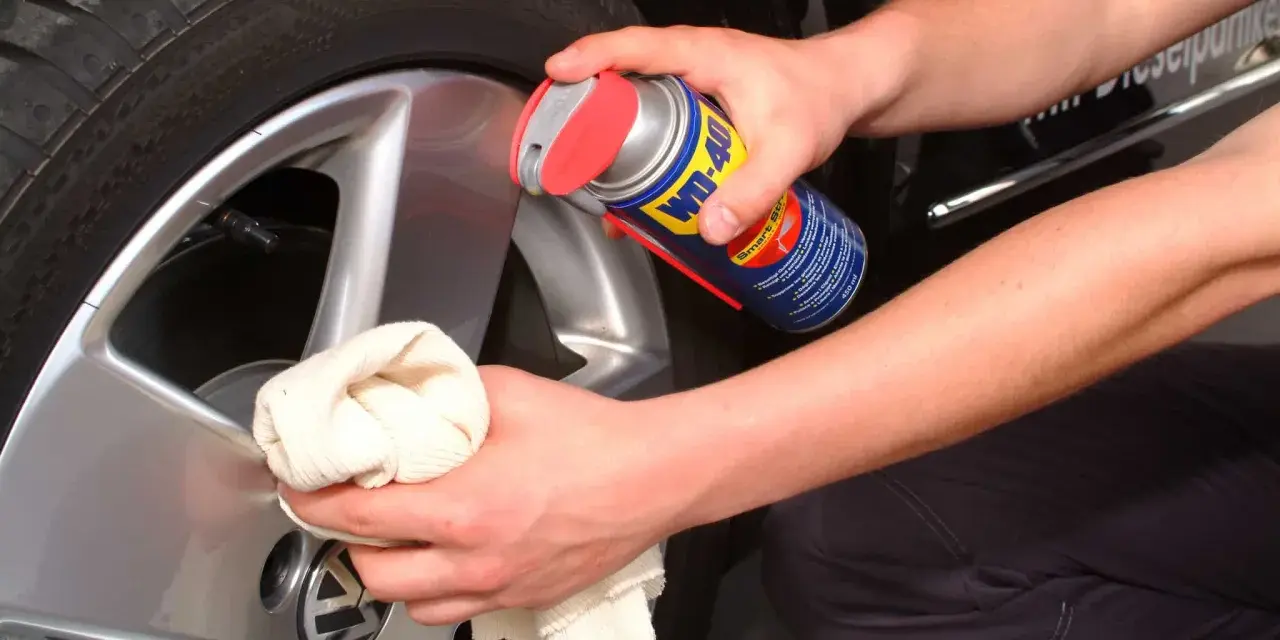 Person reinigt Felgen mit WD-40 und Tuch. Ein Hausmittel für glänzende Felgen.