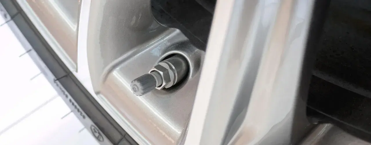 Nahaufnahme eines Autoreifenventils, das undicht zu sein scheint. Der Gummi ist leicht beschädigt.