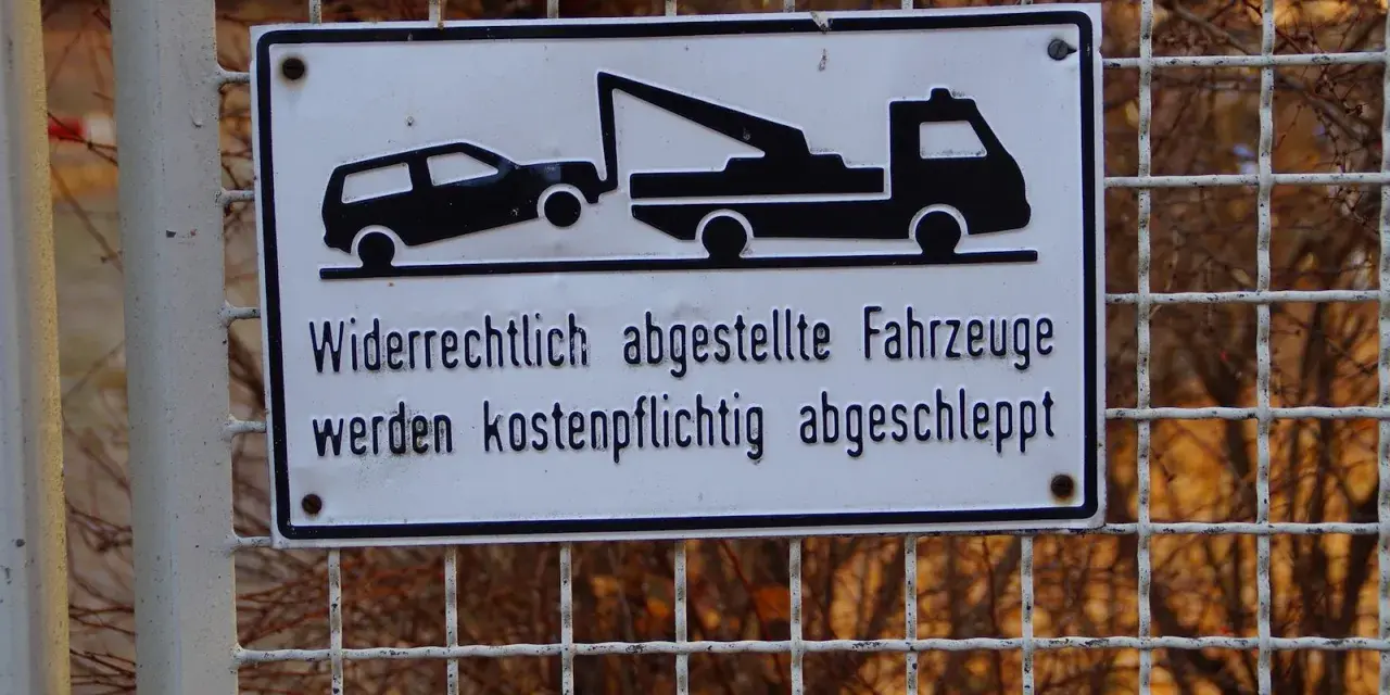 Schild: Widerrechtlich abgestellte Fahrzeuge werden kostenpflichtig abgeschleppt. Was tun, wenn das Auto abgeschleppt wurde?