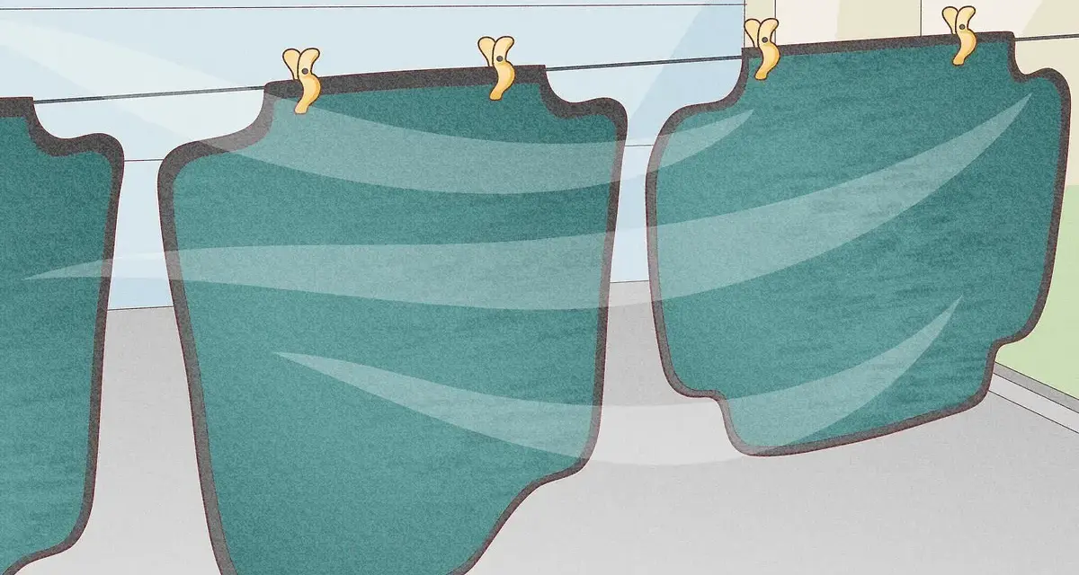 Fussmatten waschen: Mehrere grüne Automatten hängen an einer Wäscheleine und trocknen.