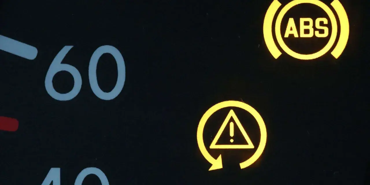 Armaturenbrett mit leuchtenden Warnleuchten: ABS und ESP-Symbol. Die ESP auto bedeutung ist, dass das elektronische Stabilitätsprogramm aktiv ist oder eine Störung vorliegt.
