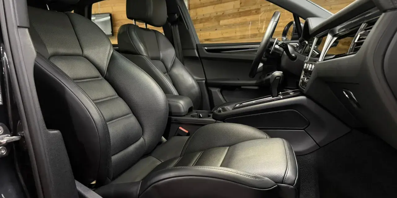 Der luxuriöse porsche macan s innenraum mit perforierten Ledersitzen und einem modernen Armaturenbrett.