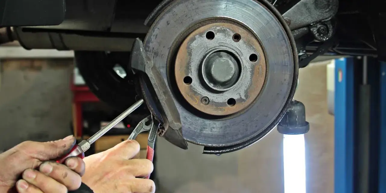 Mechaniker führt eine Inspektion am Bremssattel eines Mercedes durch. Der Service A steht an.
