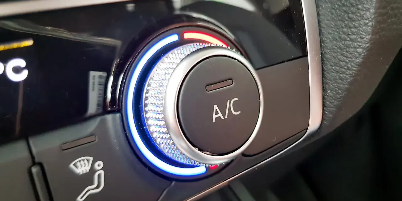 Detailaufnahme des Cockpits eines Autos. Ein Drehregler mit blauer und roter Beleuchtung steuert die Klimaanlage.