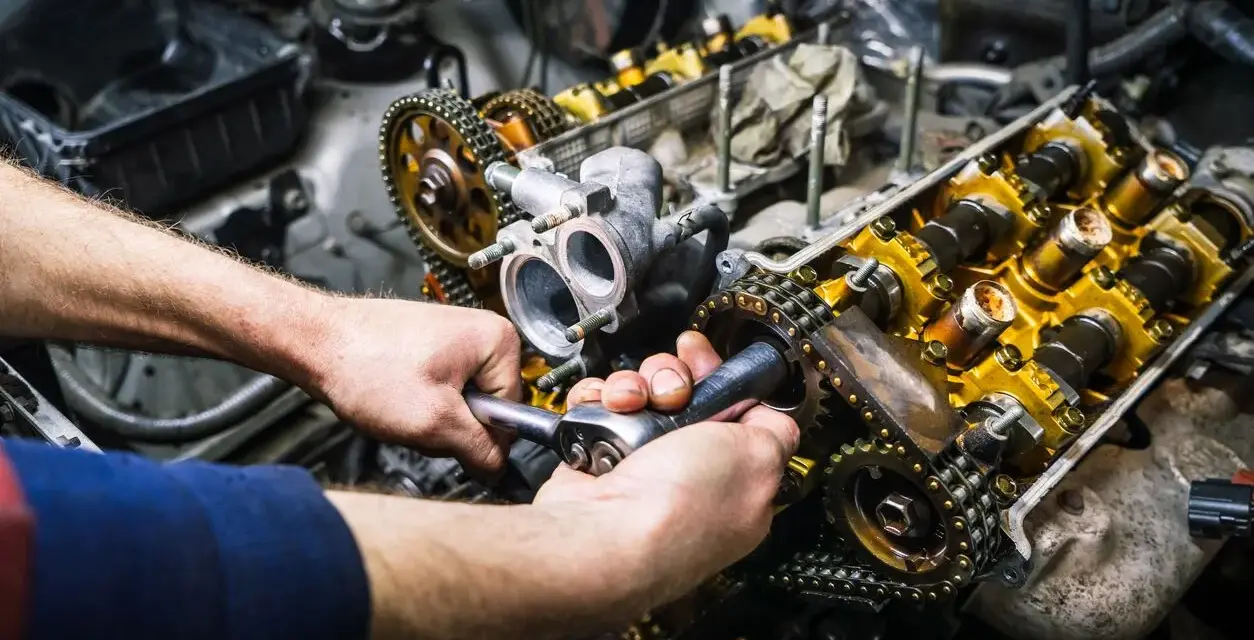 Mechaniker repariert einen Motor. Die Kosten für einen Motorschaden können hoch sein, aber eine Reparatur ist oft möglich.