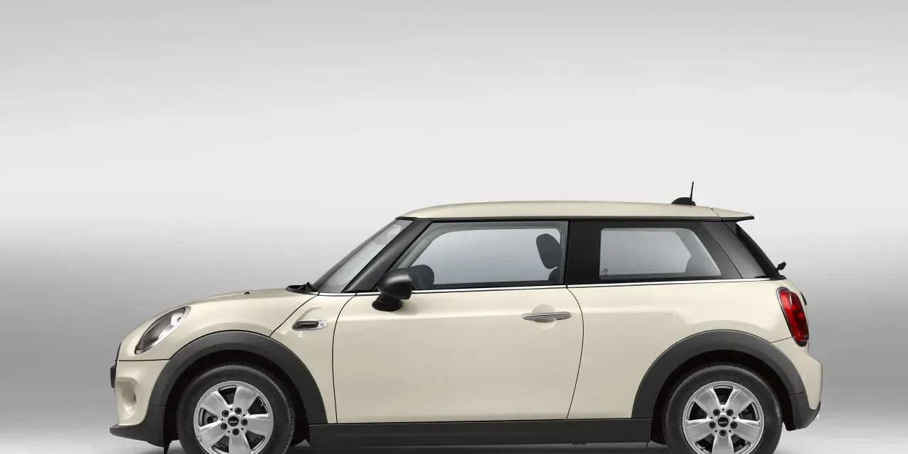Beiger Mini Cooper im Profil. Ein Blick auf den Mini Cooper wartungsplan hilft, diesen Klassiker in Topform zu halten.