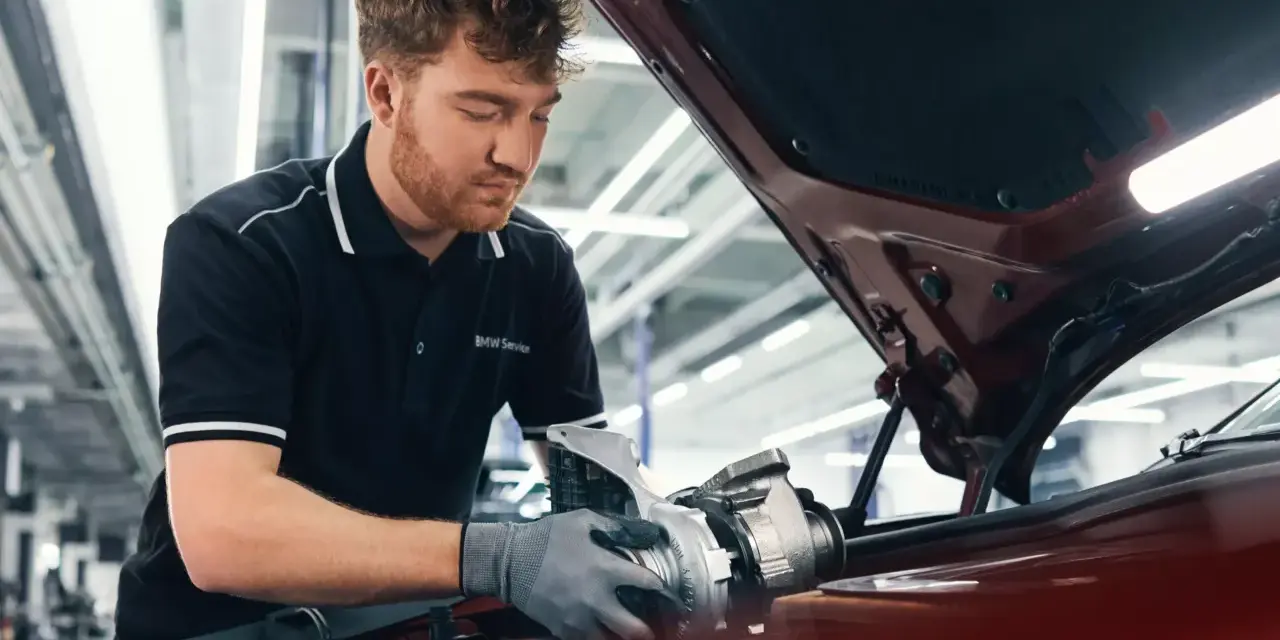 Mechaniker mit BMW Service Polohemd arbeitet an einem Turbolader für ein BMW CBS Fahrzeug.