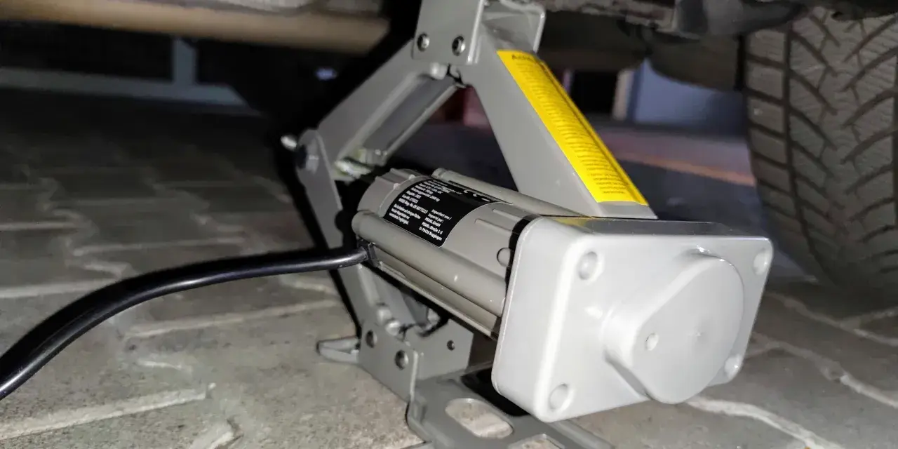 Elektrischer Wagenheber hebt das Auto an, um Reifen mit Reifendrucksensor selber zu wechseln.