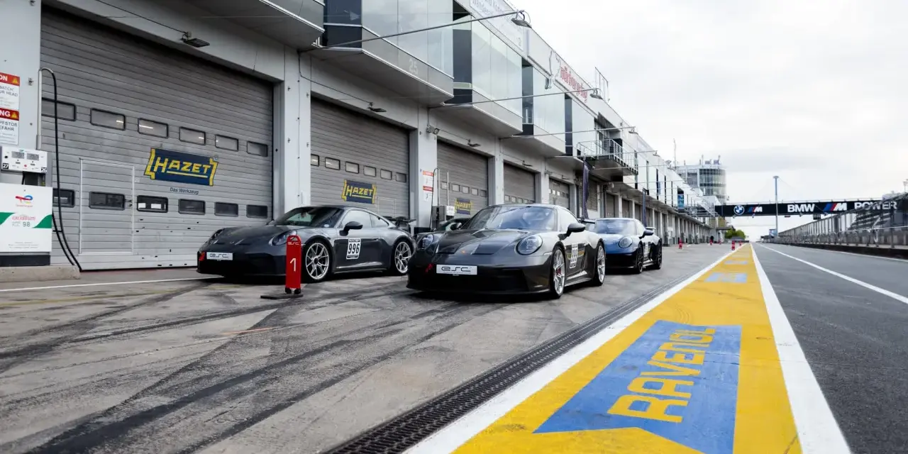 Porsche-Rennwagen in Boxengasse. Hier kann man pitstop teile selber mitbringen. Gelbe Markierungen auf dem Asphalt.