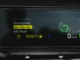 Fahrzeugdisplay zeigt Einstellungen für Traktionskontrolle (TC) und ABS. "Dyn. Slip Adj." ist hervorgehoben.
