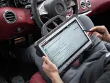 Diagnosegerät im luxuriösen Mercedes-Innenraum. Ein Techniker prüft die Daten, um die Service b Mercedes Kosten zu ermitteln.