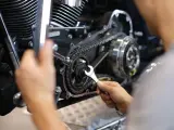 Mechaniker repariert Motorrad-Steuerkette. Die Kosten für den Wechsel der Steuerkette sind hier ein wichtiger Faktor.