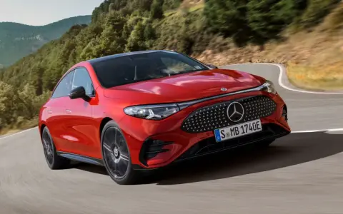 Roter Mercedes fährt kurvig durch bergige Landschaft. Perfekt für lange Fahrten, denken Sie an die Mercedes Serviceintervalle.