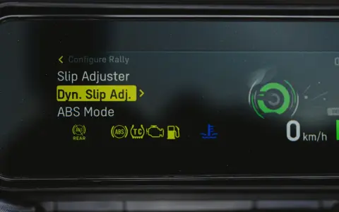 Fahrzeugdisplay zeigt Einstellungen für Traktionskontrolle (TC) und ABS. "Dyn. Slip Adj." ist hervorgehoben.