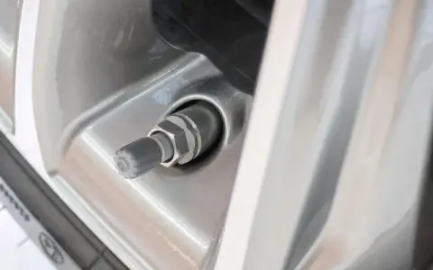 Nahaufnahme eines Autoreifenventils, das undicht zu sein scheint. Der Gummi ist leicht beschädigt.