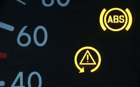 Armaturenbrett mit leuchtenden Warnleuchten: ABS und ESP-Symbol. Die ESP auto bedeutung ist, dass das elektronische Stabilitätsprogramm aktiv ist oder eine Störung vorliegt.