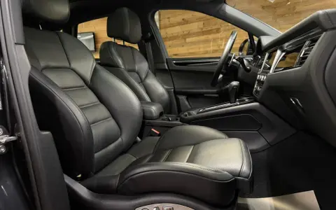 Der luxuriöse porsche macan s innenraum mit perforierten Ledersitzen und einem modernen Armaturenbrett.
