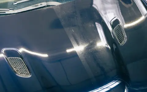 Vergleich: Eine polierte und eine matte Motorhaube. Informieren Sie sich über die auto polieren kosten für diesen Glanz.