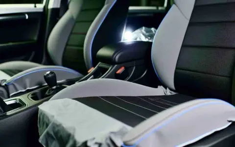 Detailaufnahme des Innenraums eines Autos, mit Fokus auf die Sitze. Die Sitze sind zweifarbig, grau und schwarz, mit blauen Akzenten. Sie scheinen bereit für die **ledersitze reparieren** zu sein.