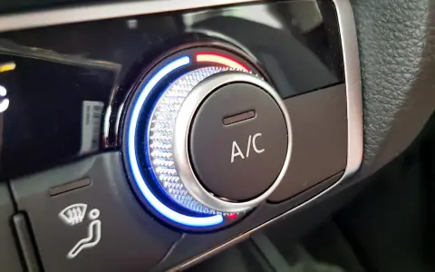 Detailaufnahme des Cockpits eines Autos. Ein Drehregler mit blauer und roter Beleuchtung steuert die Klimaanlage.