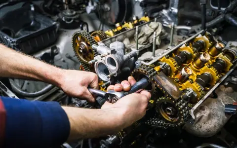 Mechaniker repariert einen Motor. Die Kosten für einen Motorschaden können hoch sein, aber eine Reparatur ist oft möglich.