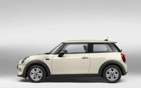 Beiger Mini Cooper im Profil. Ein Blick auf den Mini Cooper wartungsplan hilft, diesen Klassiker in Topform zu halten.
