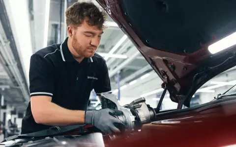 Mechaniker mit BMW Service Polohemd arbeitet an einem Turbolader für ein BMW CBS Fahrzeug.