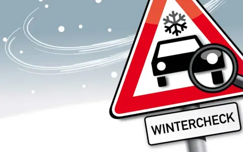 Warnschild mit Schneeflocke und Auto, Lupe zeigt auf Reifen. Darunter steht "WINTERCHECK". Bereiten Sie Ihr Fahrzeug auf den Winter vor!