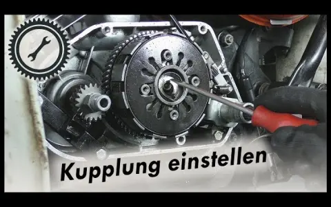 Werkzeug greift in Motorradkupplung. Ein Schraubendreher wird benutzt, um die Kupplung nachstellen.
