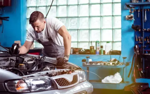 Mechaniker untersucht Motor. Er hofft, dass das Auto nach der Reparatur wieder funktioniert, aber es scheint, als ob das Auto nach Reparatur wieder defekt ist.