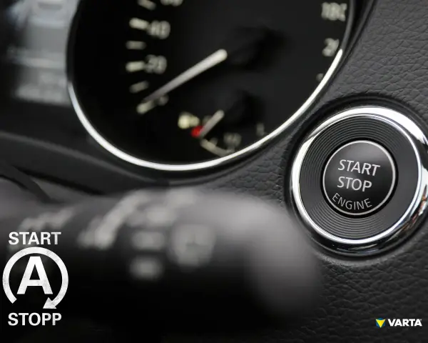 Startknopf im Auto mit Kreis und Pfeilen, bereit für die Fahrt.