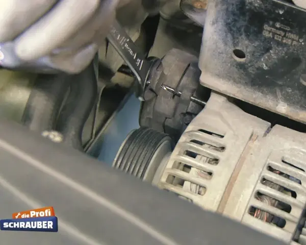 Werkzeug wird benutzt, um den Keilriemen zu spannen. Ein Keilriemen ist ein wichtiger Bestandteil des Motors.